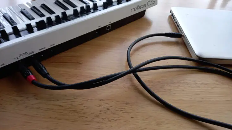 An image showing a Yamaha CS Reface connected to a MacBook Pro via audio out cables