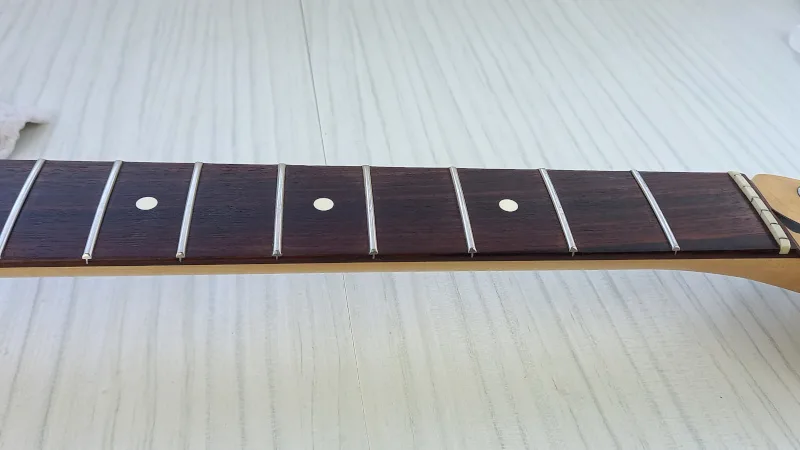 A cleaned and polished rosewood fretboard