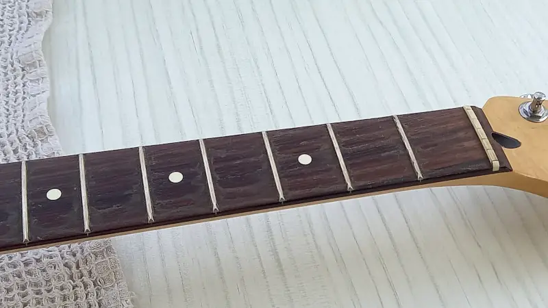 A rosewood fretboard with dirty frets