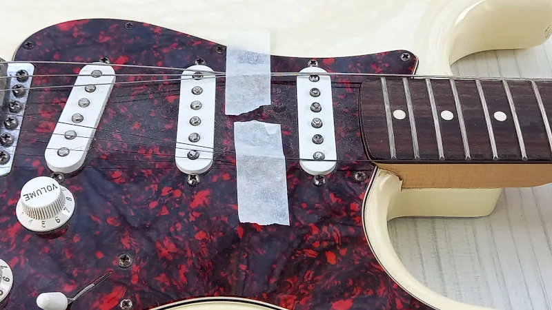 Guitar with strings taped down